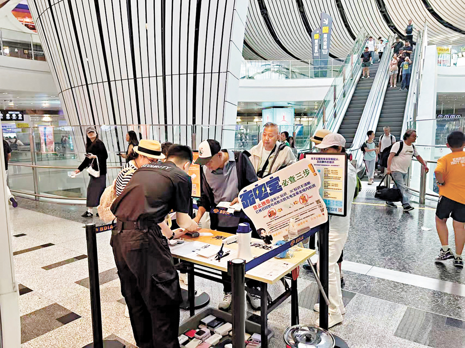 ●民航局新規出台後，機場內設置了「充電寶預檢員」檢查充電寶的3C標識。香港文匯報記者郭瀚林 攝