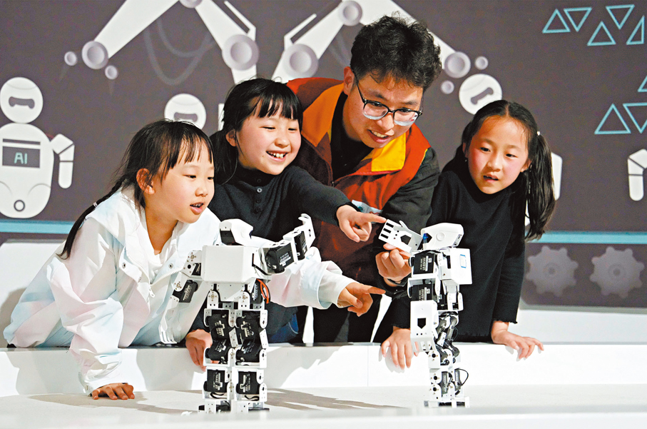 ●4月2日，志願者帶託管班孩子在江蘇省海安市科技館觀看機器人表演。 新華社