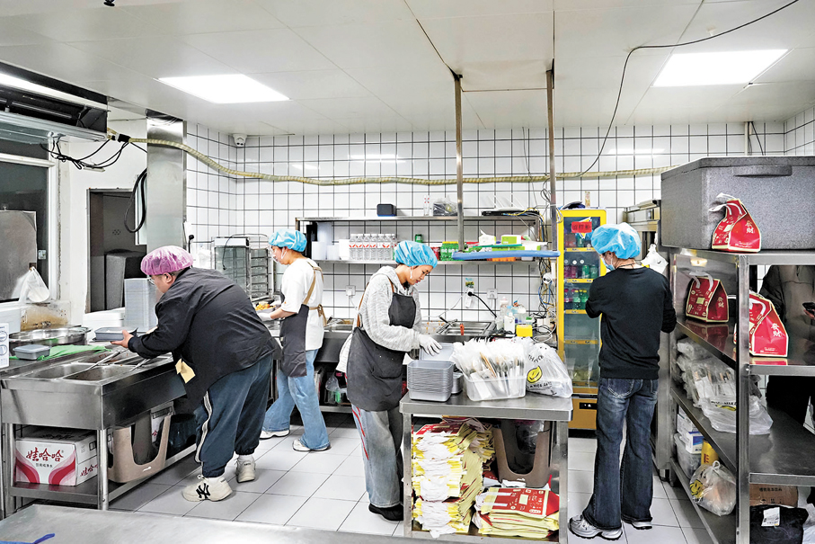 ●李先生對衞生的堅守從未改變。圖為店裏忙碌的後廚。