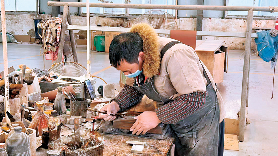 中州民族樂器有限公司內，工人正在刷漆。