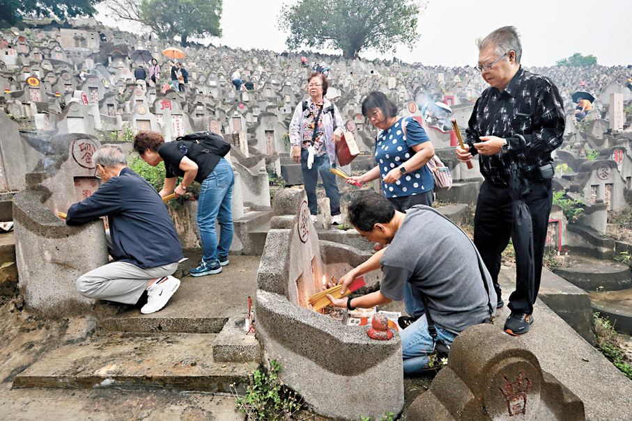 ●昨日是清明節正日，眾多孝子賢孫攜帶大小祭品、衣包，無懼風雨前往鑽石山墳場掃墓拜祭先人。香港文匯報記者郭木又  攝