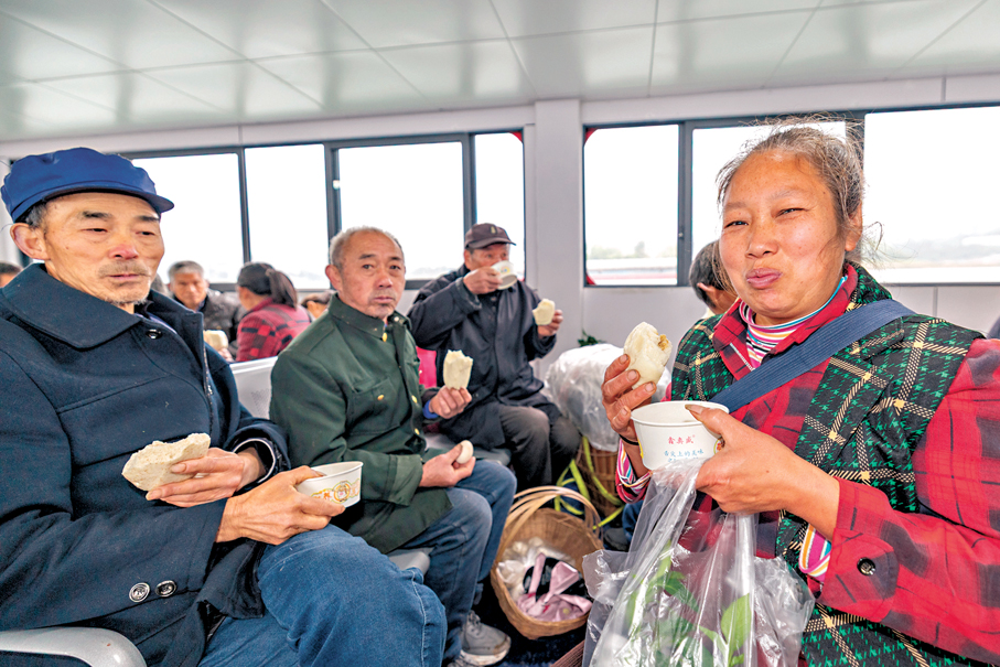 ●3月31日，在長江重慶忠縣段，乘客在「新渝忠客2180」客輪開行過程中品嘗免費愛心早餐。 新華社