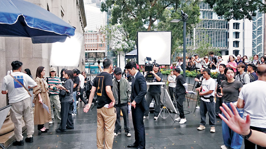 ●拍攝現場吸引大批市民冒雨圍觀。 香港文匯報記者梁靜儀 攝
