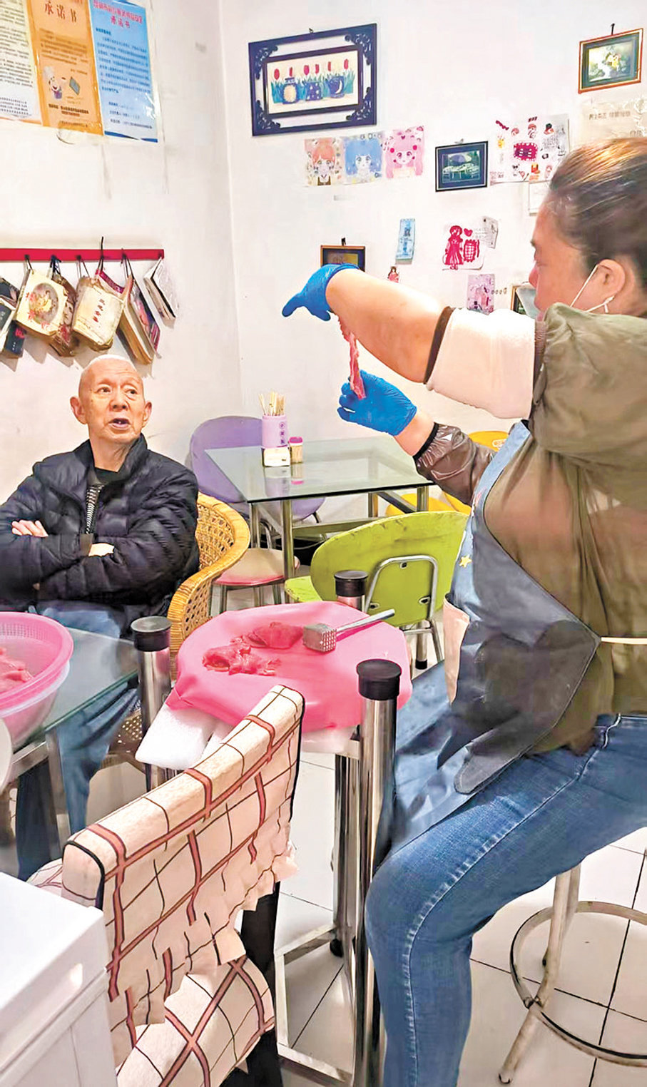 ●陳鳳鳴跟着書勝利學習豬扒的製作，她說：「爺爺可嚴格了，哪裏多錘幾下都要親自指導。」香港文匯報雲南傳真 