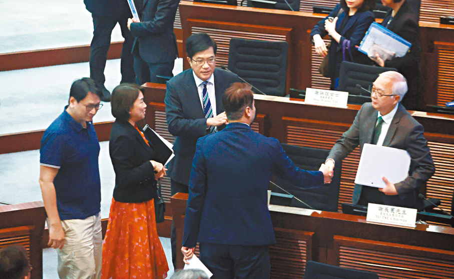 ●官員與議員握手。 香港文匯報記者郭木又  攝