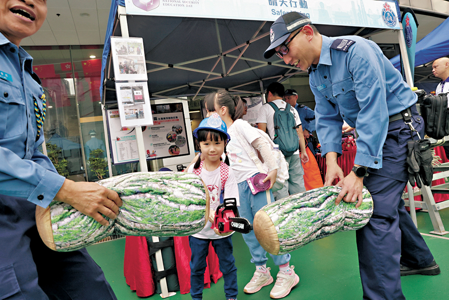 ●小朋友戴上民安隊帽子，對着鏡頭滿足地微笑。
