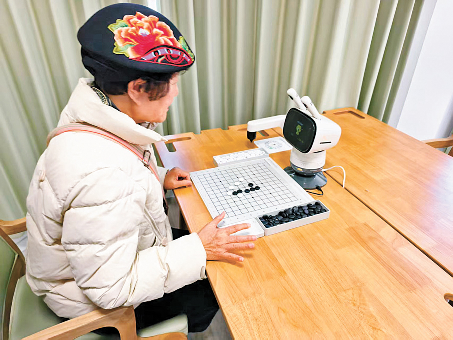 ●老人在養老驛站與機器人對弈。