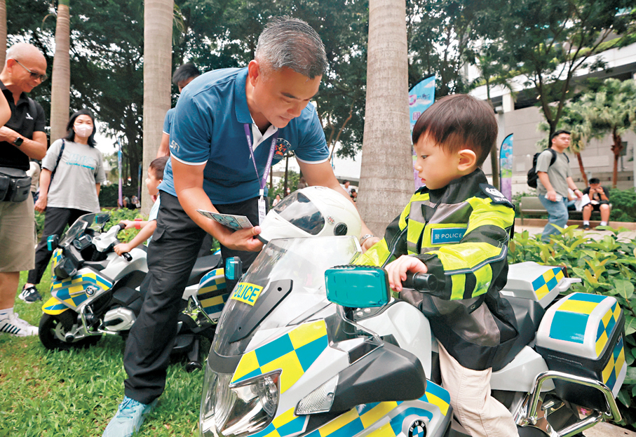 ●小朋友穿上交通警員制服坐上迷你鐵馬，體驗當上交通警員的滋味。 香港文匯報記者郭木又 攝