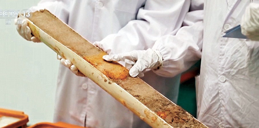 ●科研人員在研究海底的泥沙和生物遺骸中。央視截圖