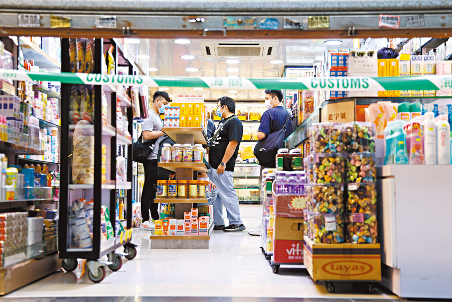 ●海關人員在涉案藥店內調查。 香港文匯報記者孫嘉蔚  攝