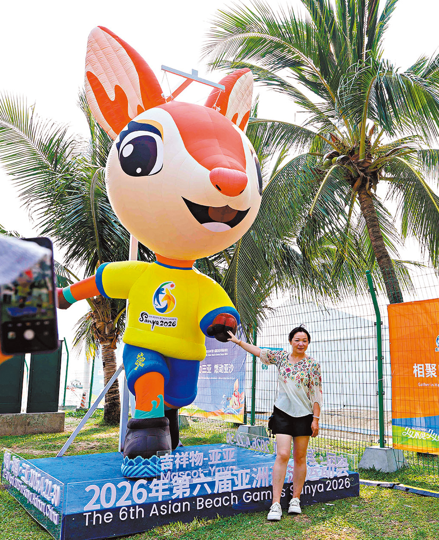 ●遊客與第六屆亞洲沙灘運動會吉祥物「亞亞」合影。  中新社