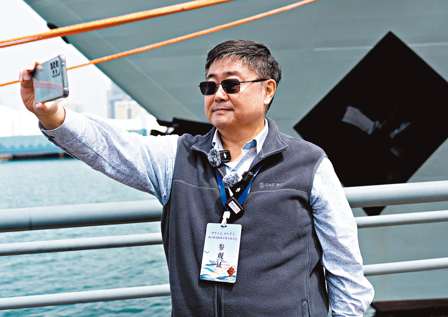 ●台灣退役艦長呂禮詩舉起手機與濰坊艦合影。
