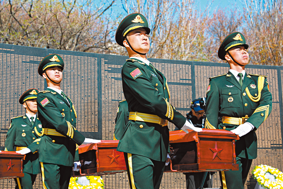 ●安葬儀式上，禮兵護送志願軍烈士遺骸棺槨走過英名牆。 香港文匯報特約通訊員陳鴻博 攝