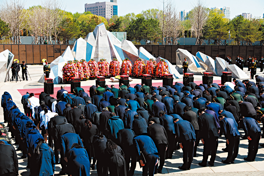 ●安葬儀式上，全體默哀。   香港文匯報特約通訊員陳鴻博  攝
