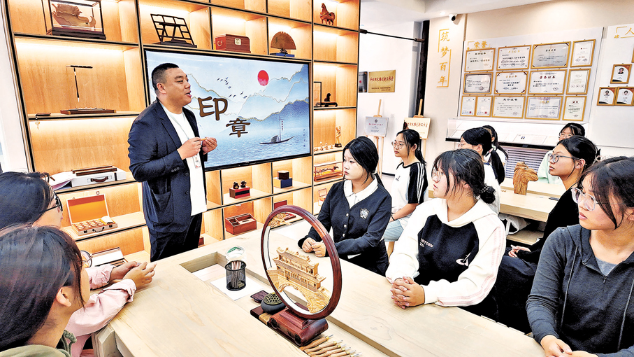 ●許紅陽為高校學生講解木雕作品的文化內涵與製作技藝。 受訪者供圖
