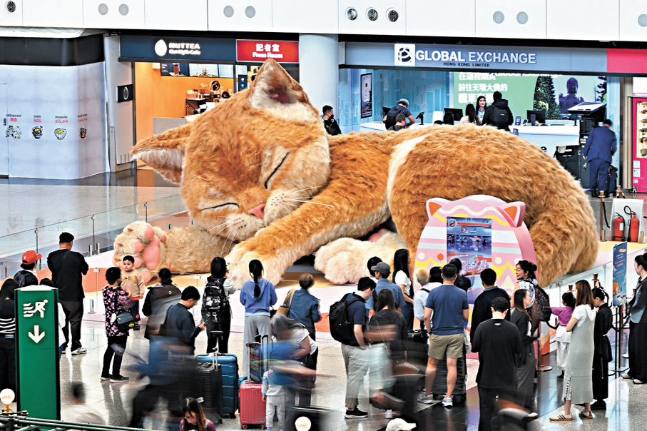 ●香港國際機場一號客運大樓抵港層的「旅途上的喵」巨型互動藝術裝置，展出至5月2日。圖為該藝術裝置吸引大批旅客圍觀。機管局圖片