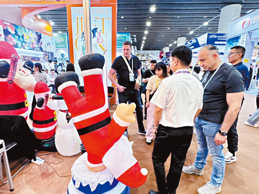●在廣交會現場，外國客商正在了解充氣聖誕老人產品。 香港文匯報記者李紫妍  攝