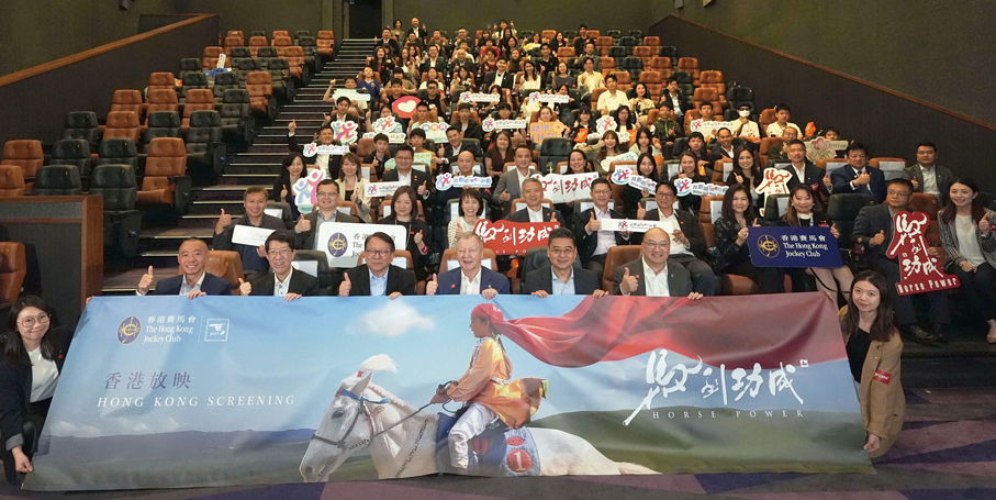 ●香港特區政府政務司司長陳國基（一排右四）、中華人民共和國外交部駐香港特區特派員公署副特派員花有（一排右二）、社會福利署署長杜永恒（一排右五）、馬會行政總裁應家柏（一排右三）、馬會公司事務執行總監譚志源（一排右一），與「共創明『Teen』」計劃的校友、友師、學員，以及合作夥伴委員會的策略夥伴委員代表等參與者，在《馬到功成》電影香港首映禮合照。