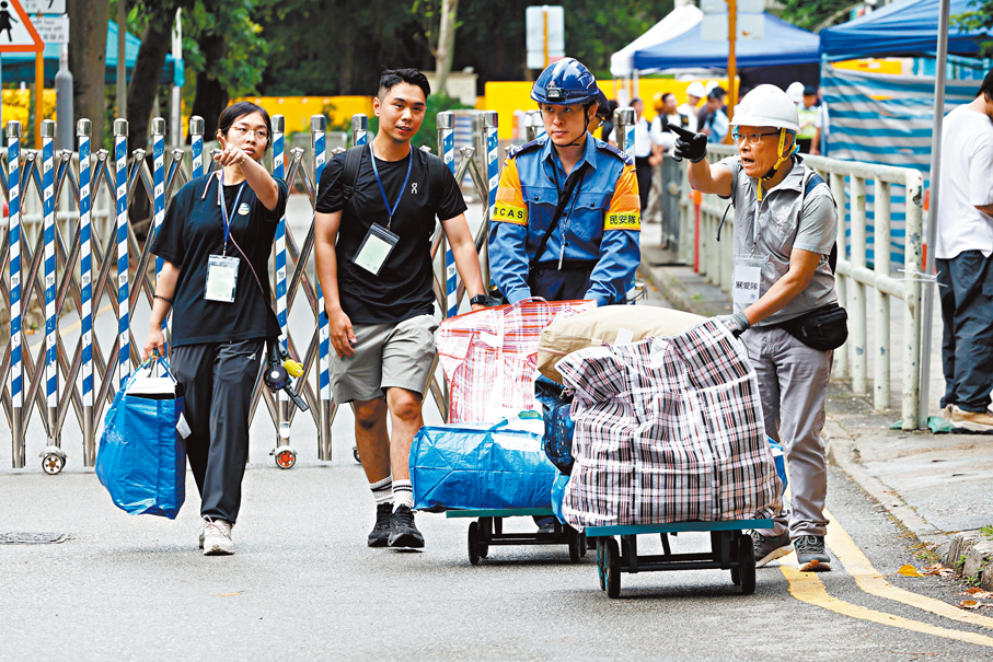 ●宏泰閣首日開放讓居民上樓執拾，關愛隊人員協助居民搬重物落樓。香港文匯報記者黃艾力  攝