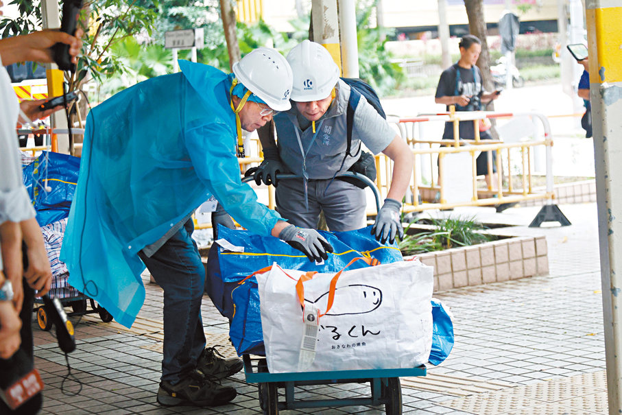 ●關愛隊人員協助居民檢查物件。香港文匯報記者黃艾力  攝