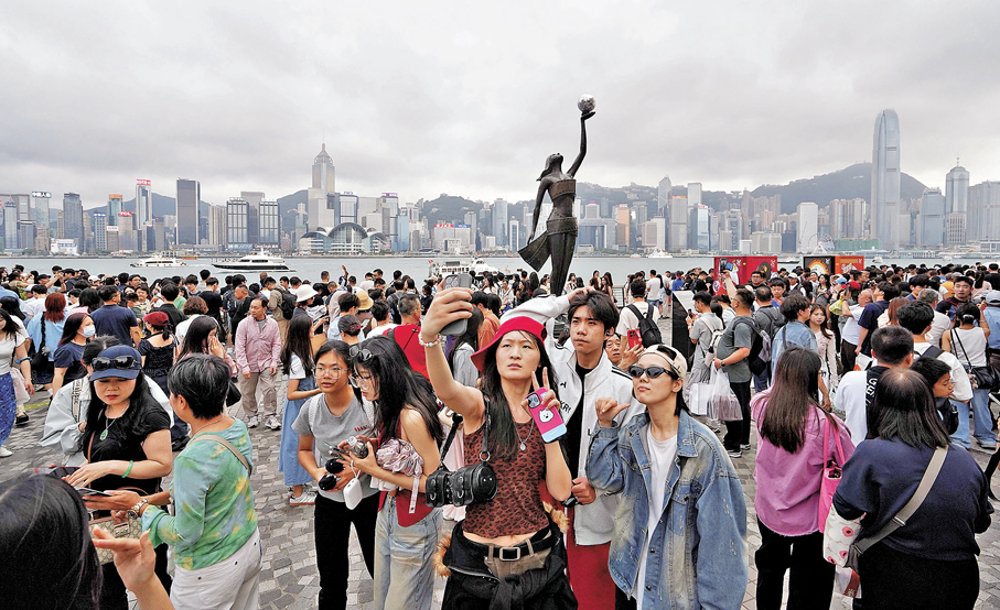 ●維港畔人潮擁擠，遊客開心自拍留念。香港文匯報記者曾興偉 攝