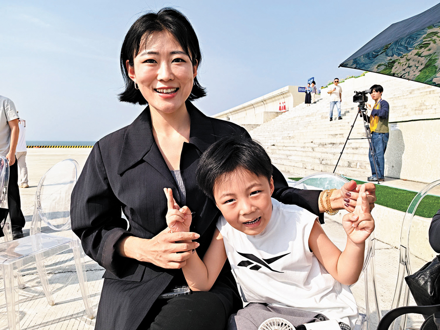 ●家住香港的親子遊客陳女士與孩子一同觀賞音樂會。 香港文匯報記者郭若溪  攝