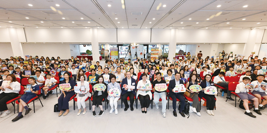 ●香港公共圖書館於4月23日與不同持份者合作設立「共讀點」，舉行「共讀半小時」活動。康樂及文化事務署（康文署) 助理署長（圖書館及發展） 李子俊（前排左六）、公共圖書館諮詢委員會主席羅乃萱（前排左五）、香港學校圖書館主任協會會長黃毅娟（前排左七）與中小學生合照。