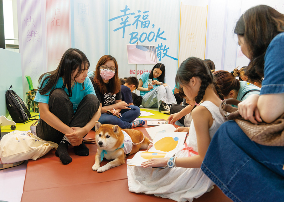 ●小朋友於九龍塘又一城商場「快閃圖書館@香港悅讀周2026」活動中體驗專業治療犬輔助伴讀。