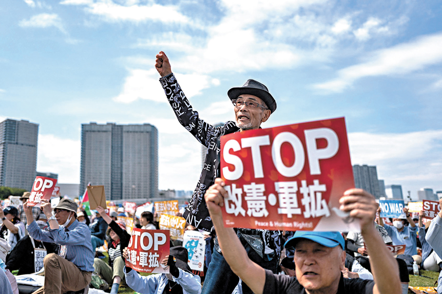 ●有長者挺身而出，來到集會現場抗議，高舉「停止軍備擴張」、「停止修憲」等標語。 法新社