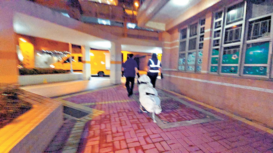●男死者的遺體由仵工舁送殮房。