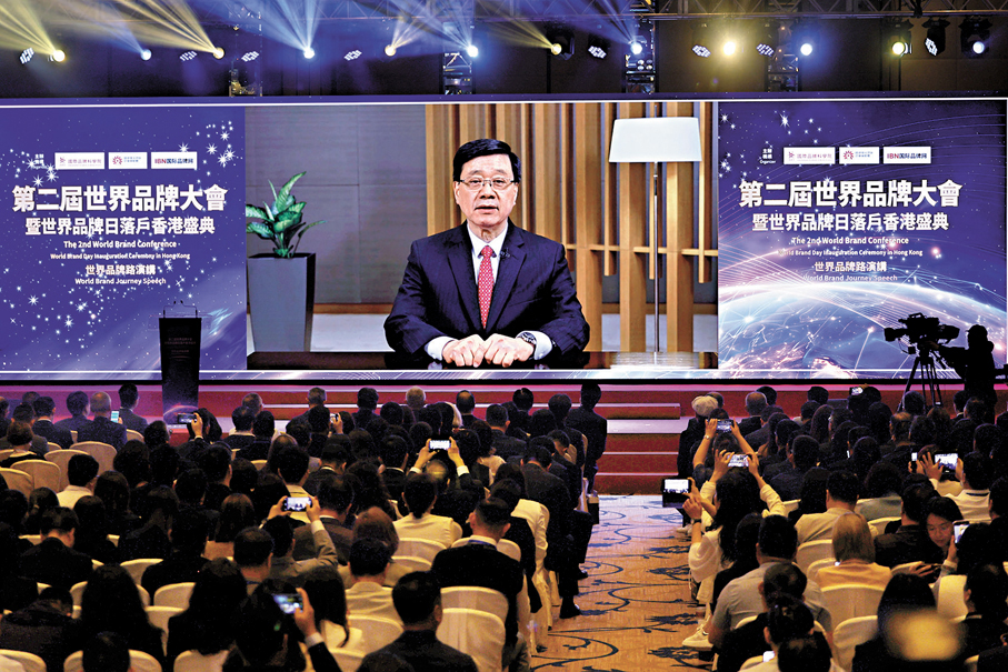 ●李家超以視像在第二屆品牌大會暨世界品牌日落戶香港盛典致辭。香港文匯報記者黃艾力  攝
