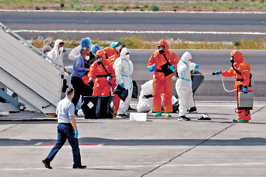 ●「洪迪厄斯號」乘客在停機坪上接受消毒。 路透社
