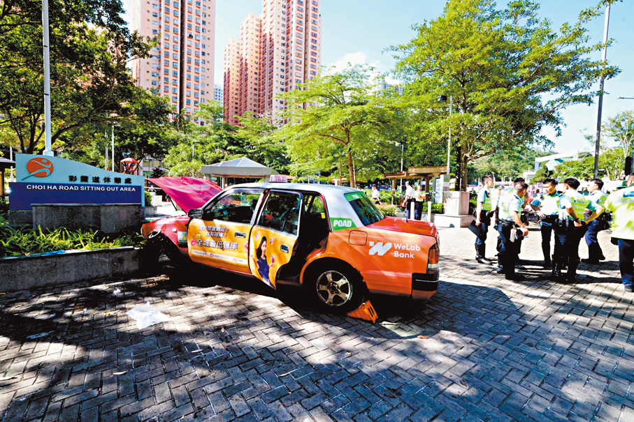 ●的士失控剷上行人路撞向休憩公園的石壆，車頭嚴重損毀，警方封鎖現場調查。 香港文匯報記者劉友光  攝