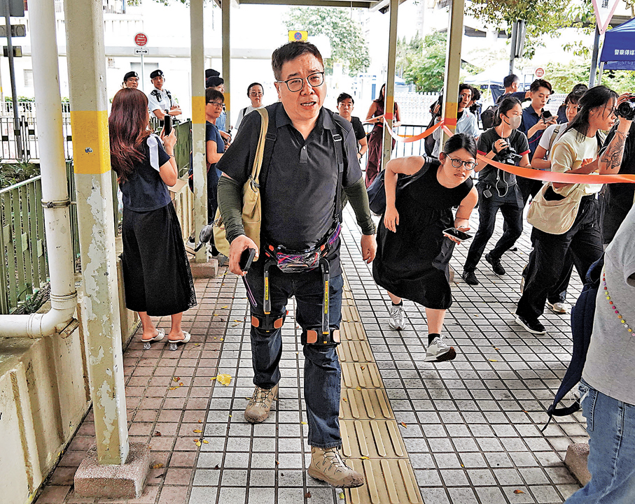 ●譚先生在首輪上樓執拾中，裝備了外骨骼裝置輔助行樓梯。香港文匯報記者曾興偉  攝