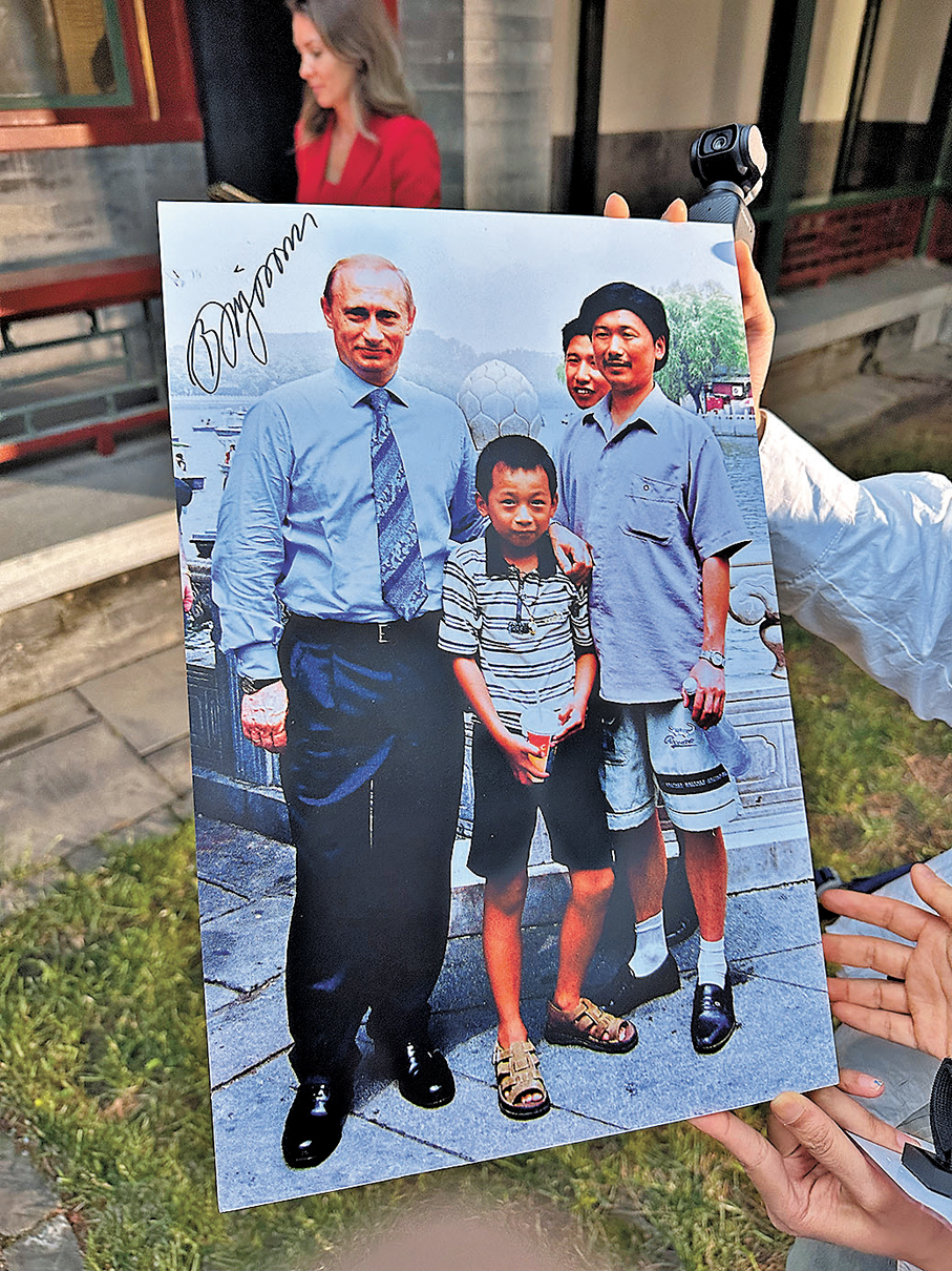 ●普京在當年合影的放大照片上簽名留念。 香港文匯報記者蘇雨潤 攝