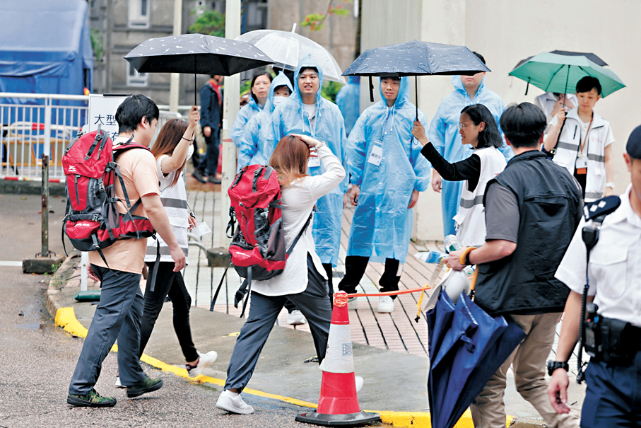 ●昨日上午正值滂沱大雨，但無阻現場一眾人員傾力支援居民上樓執拾。香港文匯報記者黃艾力  攝