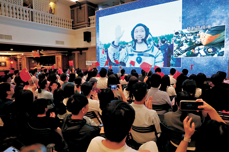 ●巿民在商場觀看神舟二十三號升空直播，為黎家盈加油打氣。 香港文匯報記者林兆崙  攝