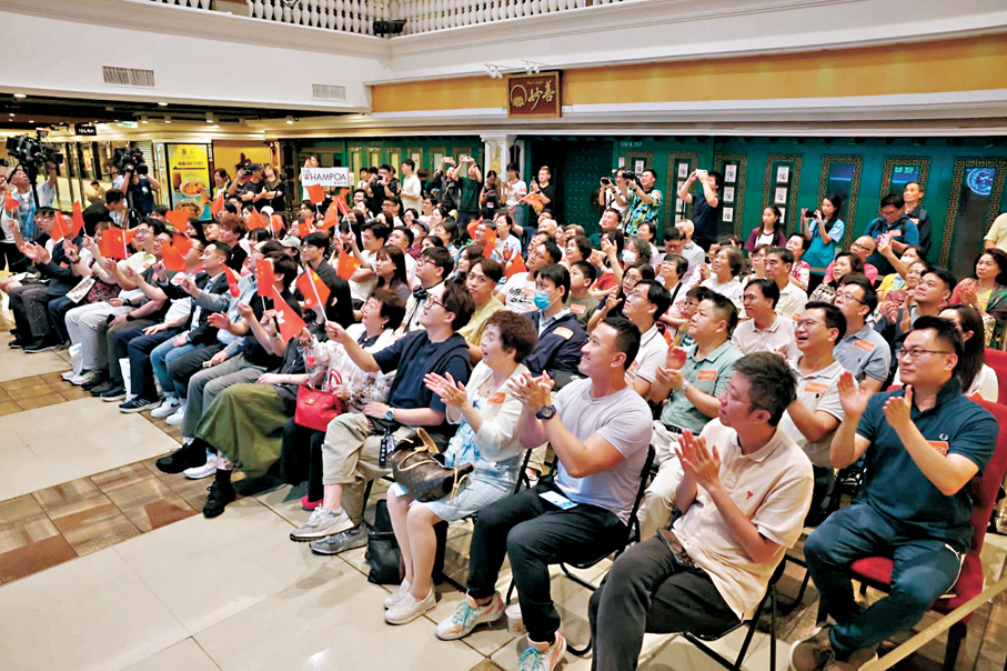 ●巿民在商場觀看神舟二十三號升空直播，為黎家盈加油打氣。 香港文匯報記者林兆崙  攝