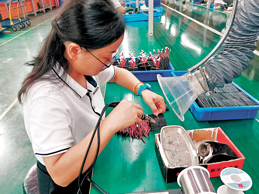 ●一女員工正在深圳廠房裝配太陽能燈。 香港文匯報記者李昌鴻  攝