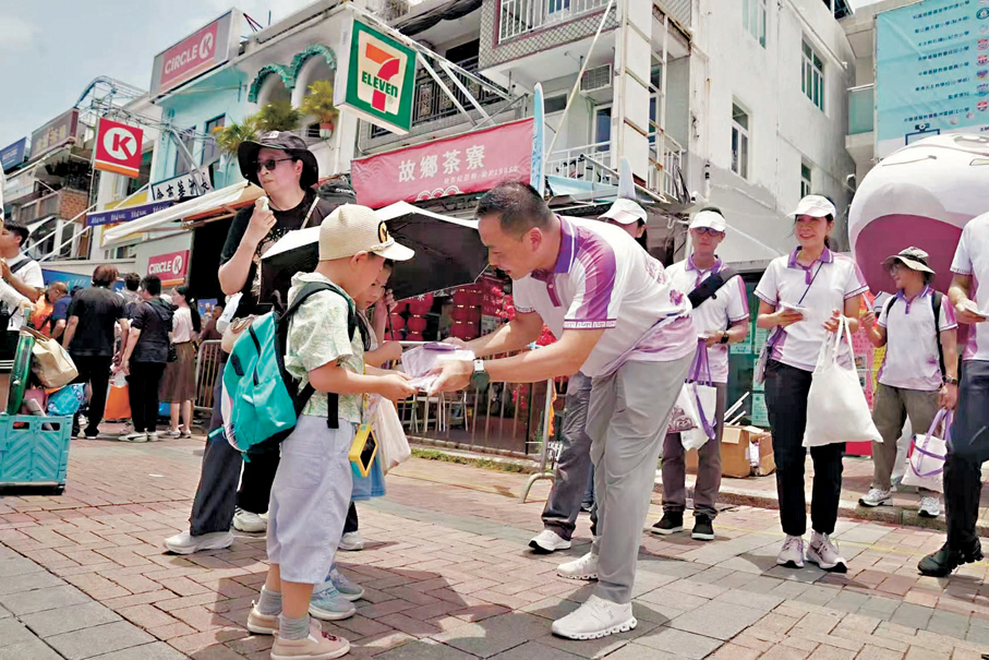 ●警務處國家安全處處長江學禮向小朋派發國安紀念品。 主辦方供圖