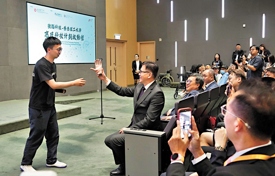 ●孫東感受智能手手掌的靈活。 香港文匯報記者曾興偉  攝