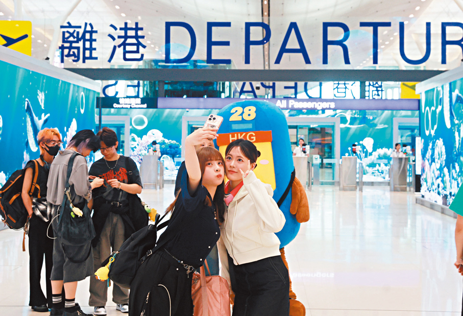 ●旅客離境前與機場吉祥物打卡。 香港文匯報記者郭木又  攝