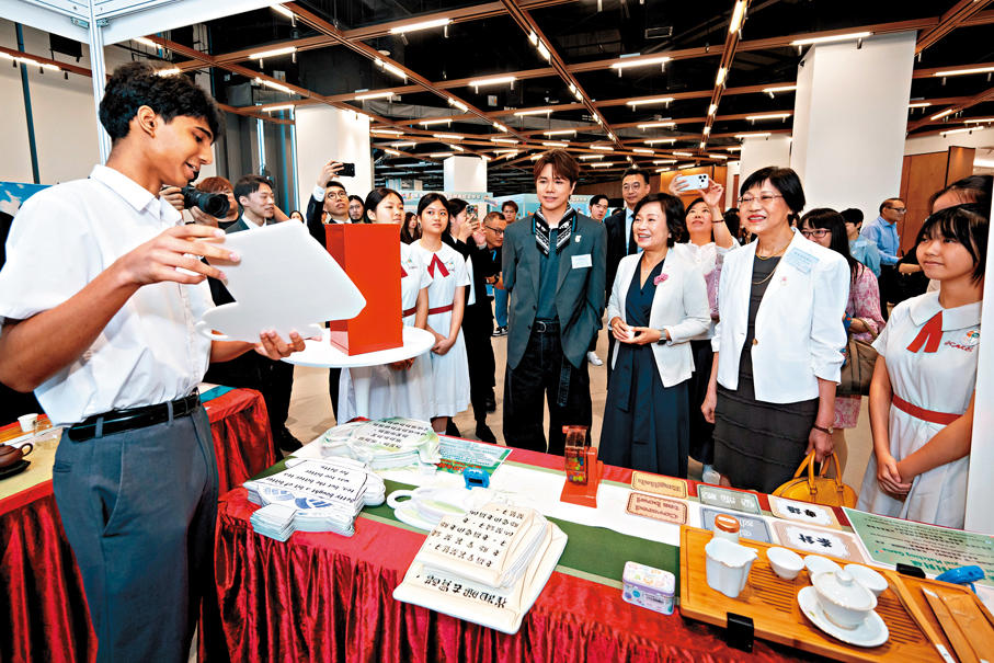 ●蔡若蓮（右三）與語常會主席陳黃麗娟（右二）和語常會三十周年大使張敬軒（右四）在展覽攤位與學生語文大使互動。