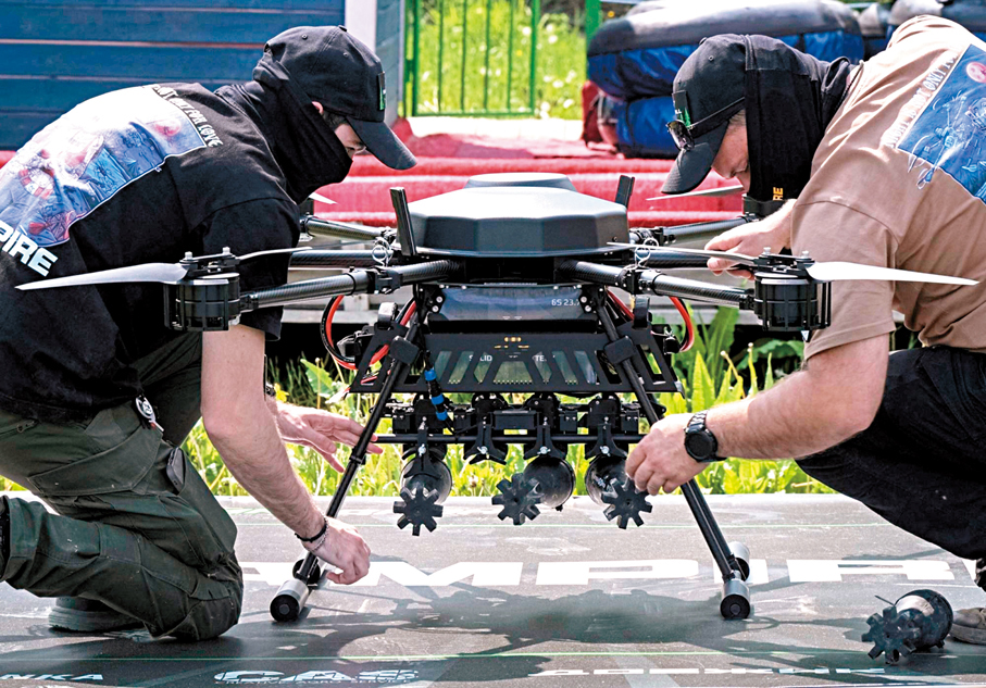 ●兩名烏軍正在檢查一架重型戰鬥無人機。  路透社
