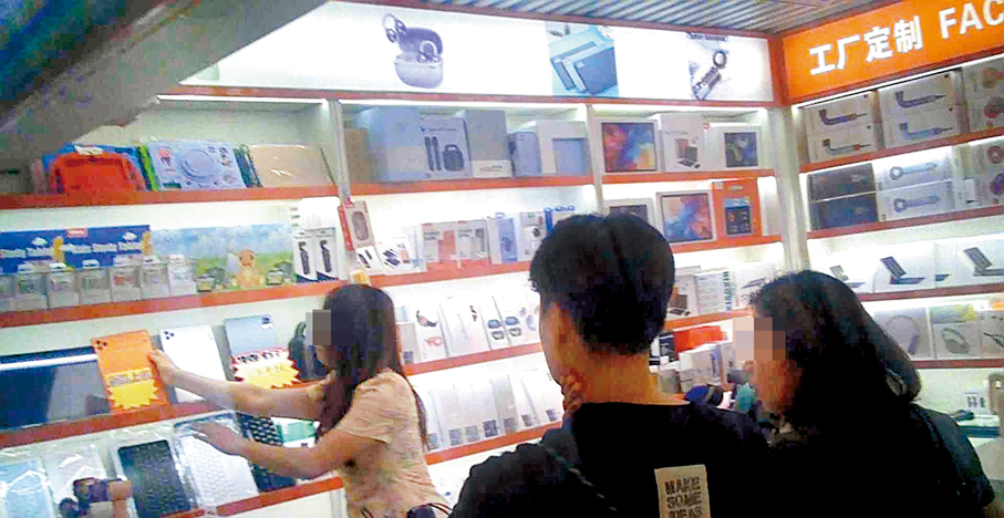 ●世界盃即將揭幕，有港客在華強北商舖內圍攏，向店員端詳及查詢看球平板電腦的詳情。   香港文匯報記者廣濟  攝