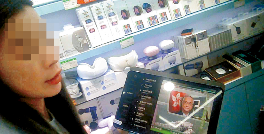 ●華強北商戶女店員手持一部已聯網的平板電腦，向記者展示其可實時收看本港及海外多個付費電視頻道。 香港文匯報記者廣濟  攝