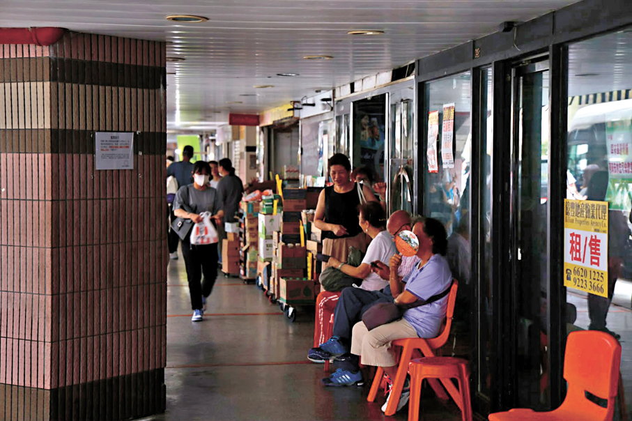 ●受停電影響，有居民在樓下店舖外乘涼。香港文匯報記者孫嘉蔚  攝