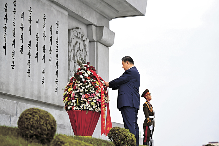●6月9日上午，正在朝鮮進行國事訪問的中共中央總書記、國家主席習近平和夫人彭麗媛參謁中朝友誼塔。朝鮮勞動黨總書記、國務委員長金正恩和夫人李雪主陪同。這是習近平整理花籃緞帶。 新華社