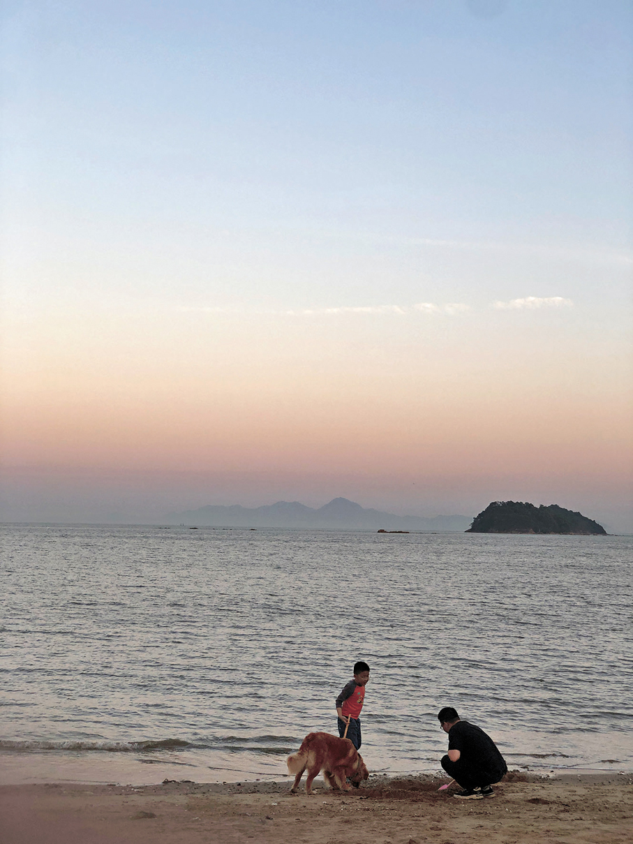 ●一對父子在珠海海灘上遊玩。