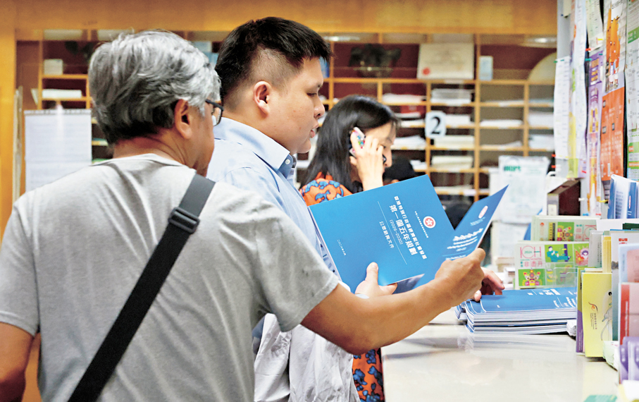 ●為期兩個月的香港五年規劃公眾諮詢昨日展開。圖為市民領取公眾諮詢文件，以了解香港五年規劃。香港文匯報記者郭木又  攝
